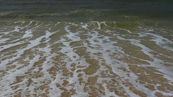 mooi golven Aan de zand strand achtergrond. video