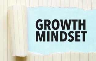 Text growth mindset appearing behind torn white paper photo