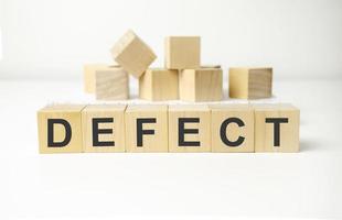 defect word made with wooden blocks and white background photo