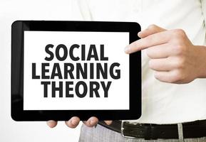 Text social learning theory on tablet display in businessman hands on the white background. Business concept photo