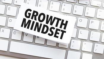 Text growth mindset written on paper sheet on a computer keyboard photo