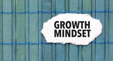 Text growth mindset on the piece of paper on the green wood background photo