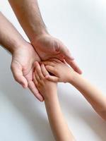 adulto y niño sostener su manos juntos. padres día niño da mano a adulto foto