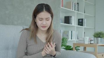 hand hold chest with heart attack symptoms, asian woman have chest pain caused by heart disease, leak, dilatation, enlarged coronary heart, press on the chest with a painful expression video