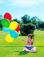 Child with balloons on the field photo