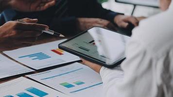 Financial analysts analyze business financial reports on a digital tablet planning investment project during a discussion at a meeting of corporate showing the results of their successful teamwork. video
