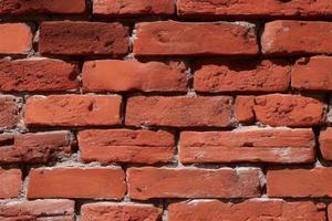 Collapsing red brick wall. The texture of the brickwork. Layered clay bricks in the wall of the building. Multitask background. photo