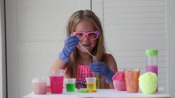 The child conducts experiments. Connects in test tubes fluids of different colors. video