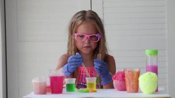 The child conducts experiments. Connects in test tubes fluids of different colors. video