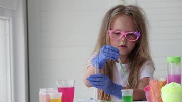 il bambino conduce esperimenti. si connette nel test tubi fluidi di diverso colori. video