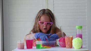 The child conducts experiments. Connects in test tubes fluids of different colors. video