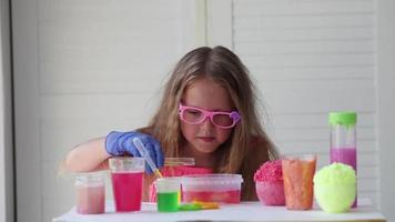 The child conducts experiments. Connects in test tubes fluids of different colors. video