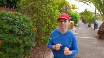 Frau Joggen entlang das Straße unter das tropisch Gasse video