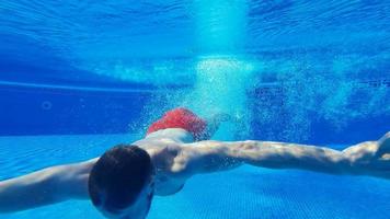 submarino disparo como un hombre inmersiones dentro el piscina y nada debajo el agua video