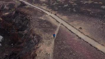 Aerial view of woman runs along the oceanfront nature reserve at sunrise. Healthy active lifestyle video