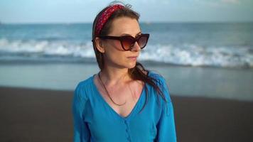 Portrait of a woman in a beautiful blue dress on a black volcanic beach video