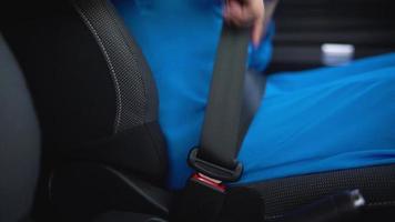 Woman unfastening car safety seat belt while sitting inside of vehicle after driving video