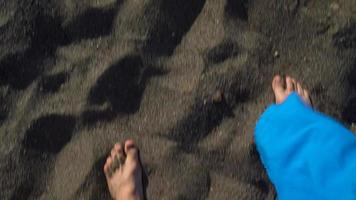 superiore Visualizza di coppia passeggiando insieme a il nero vulcanico sabbia a oceano spiaggia video