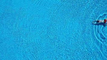 Aerial view of man in red shorts swims in the pool video