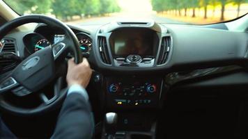 uomo guida un' auto su il strada nel soleggiato tempo metereologico e perdente controllo durante il giro. Visualizza a partire dal dietro a il autista video