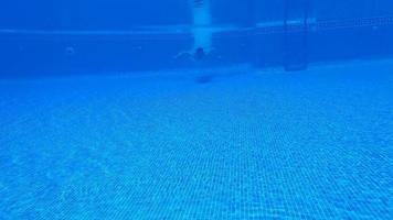 submarino disparo como un hombre inmersiones dentro el piscina y nada debajo el agua video