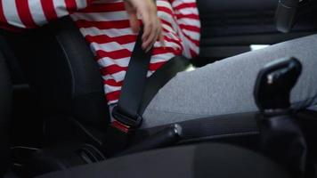 Woman fastening car safety seat belt while sitting inside of vehicle before driving video
