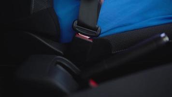 Woman unfastening car safety seat belt while sitting inside of vehicle after driving video