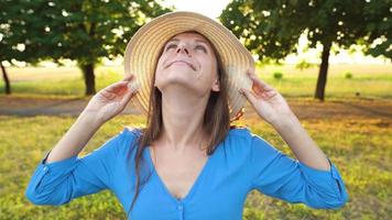 Portrait of pretty woman with hat outdoors in sunny day closeup video