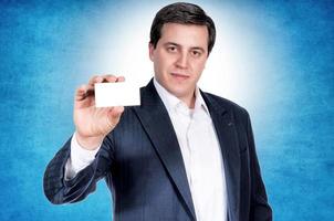 Serious businessman with blank card photo