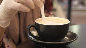 vrouw hand- in beschermend handschoenen roeren koffie met lepel video
