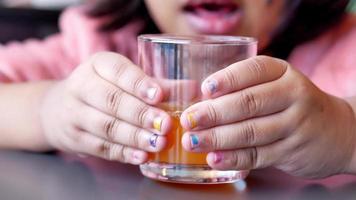 child drinking orange juice closeup, video