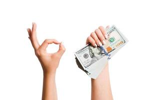 Isolated image of dollars in one hand and showing okay gesture with another hand. Top view of business concept photo