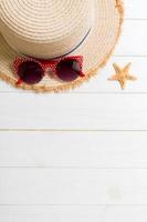 Straw hat, sunglasses and starfish On a white wooden background. top view summer holiday concept with copy space photo