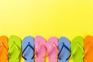 a lot of flip flop colored sandals, summer vacation on colored background, copy space top view photo