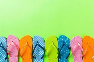 un montón de sandalias de colores flip flop, vacaciones de verano sobre fondo de color, vista superior del espacio de copia foto