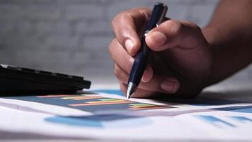 man hand with pen analyzing charts video