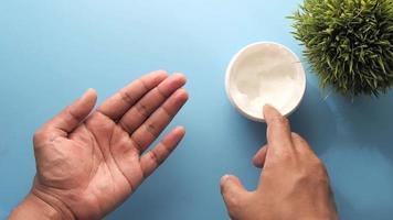 Man applying beauty cream onto skin at home top view video