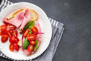 Bruschetta tomate emparedado jamón, lechuga bocadillo comida comida bocadillo en el mesa Copiar espacio comida antecedentes rústico parte superior ver foto