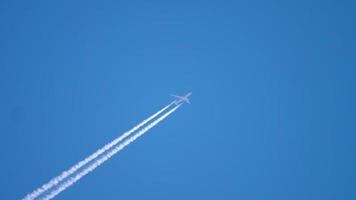 Airplane vapor white trail on blue sky, aircraft layer pollution video