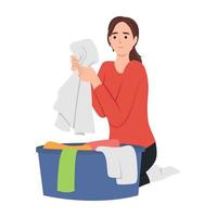 Young woman doing housework chores sorting dirty laundry in clothes basin vector