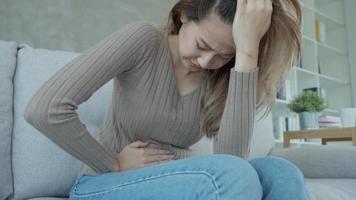 stomach ache. Asian women have abdominal pain, indigestion, gastritis, menstrual cramps, flatulence, diarrhea, distention, colon cancer, belly inflammation problem, suffer food poisoning, abdomen video