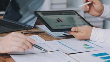 Financial analysts analyze business financial reports on a digital tablet planning investment project during a discussion at a meeting of corporate showing the results of their successful teamwork. video