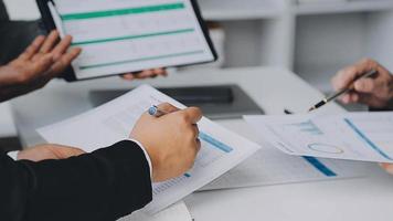 Financial analysts analyze business financial reports on a digital tablet planning investment project during a discussion at a meeting of corporate showing the results of their successful teamwork. video