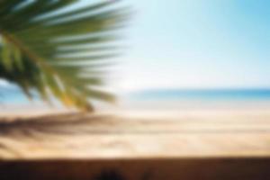 Blurred background, wooden table with a palm tree on the background of the sea. Copy space. photo