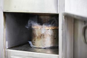 metal maceta con serrín y fumar en un industrial horno para de fumar pez. foto