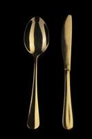 Gold knife and spoon on a black background. Cutlery. photo