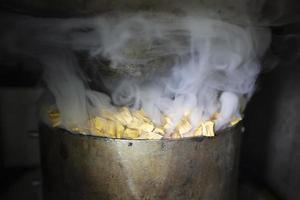 Metal pot with sawdust and smoke in an industrial oven for smoking fish. photo