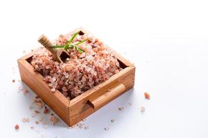 Himalayan pink salt on wooden box isolated on white background with copyspace photo