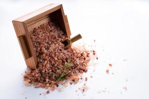 Himalayan pink salt on wooden box isolated on white background with copyspace photo