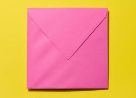 Square pink envelope on a yellow background photo